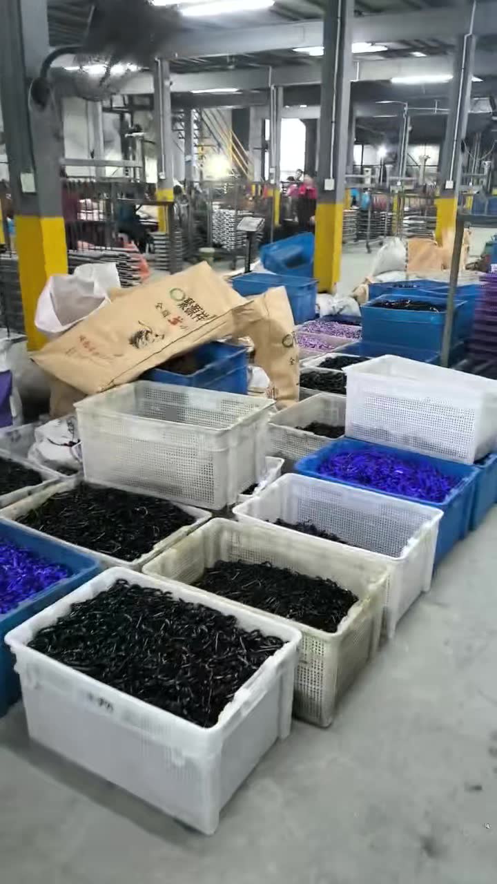 Finished aluminum carabiners in crates on the factory floor