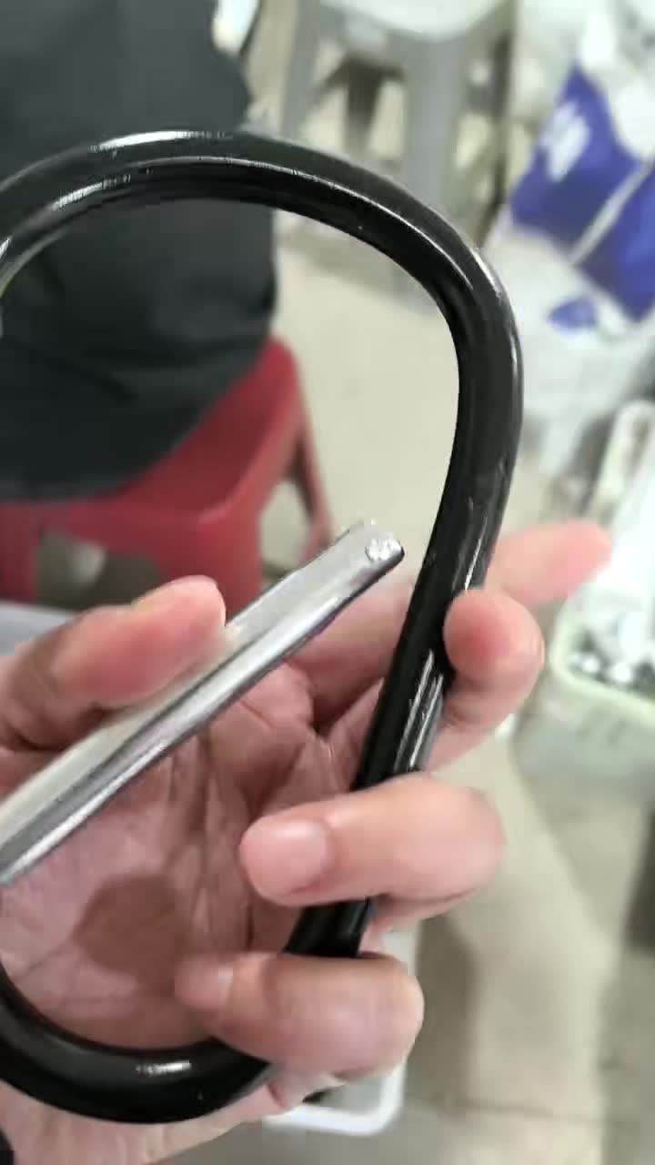 Hand quality check of a black aluminum carabiner